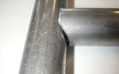 Close‑up of pipe notching on a chain‑link gate rail
